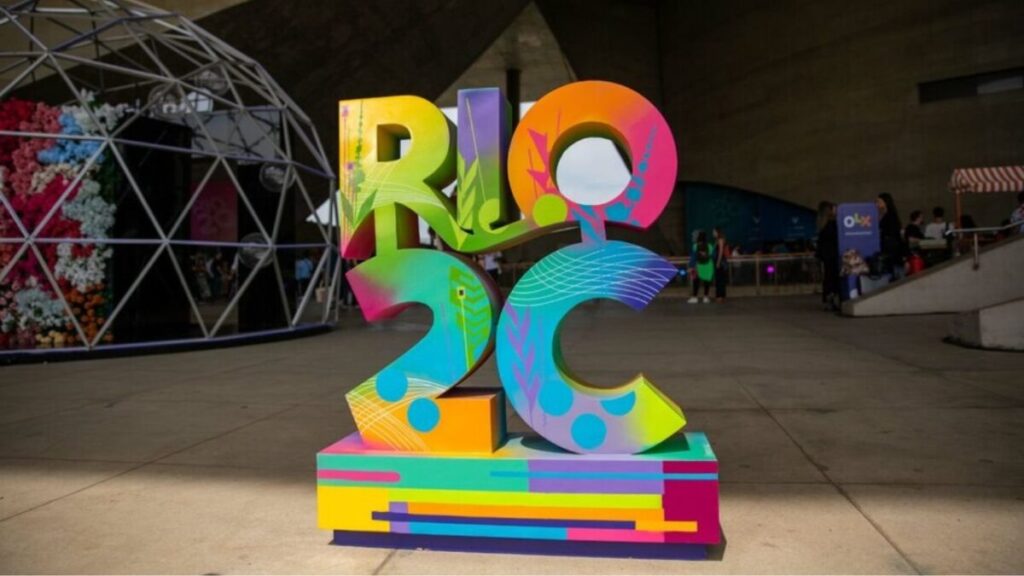 Artistas confirmados para o Rio2C 2026, incluindo IZA, João Gomes e Alcione, em um evento musical na Cidade das Artes, Rio de Janeiro.